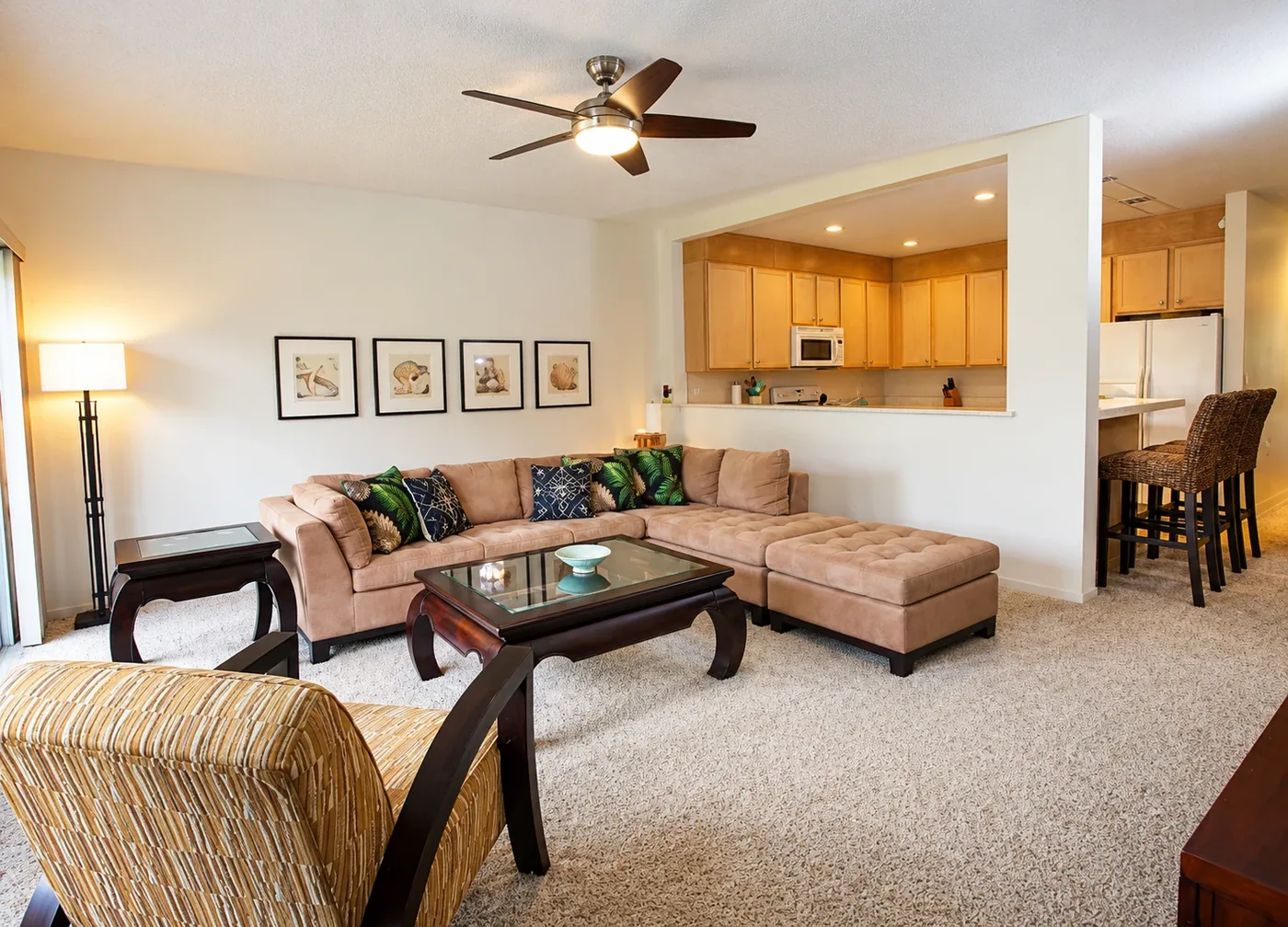 Dark five-blade ceiling fan with a light kit installed over a living room, mounted and balanced by AllPro AG in San Diego