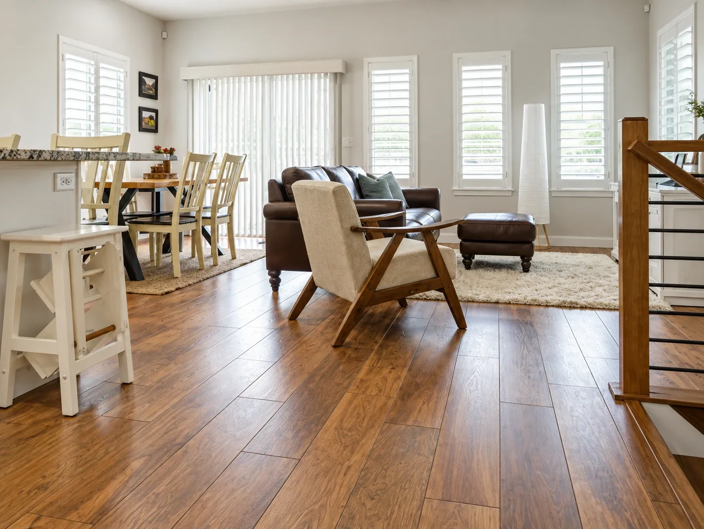 Warm wood-plank flooring running continuously through an open living and dining room in a San Diego home