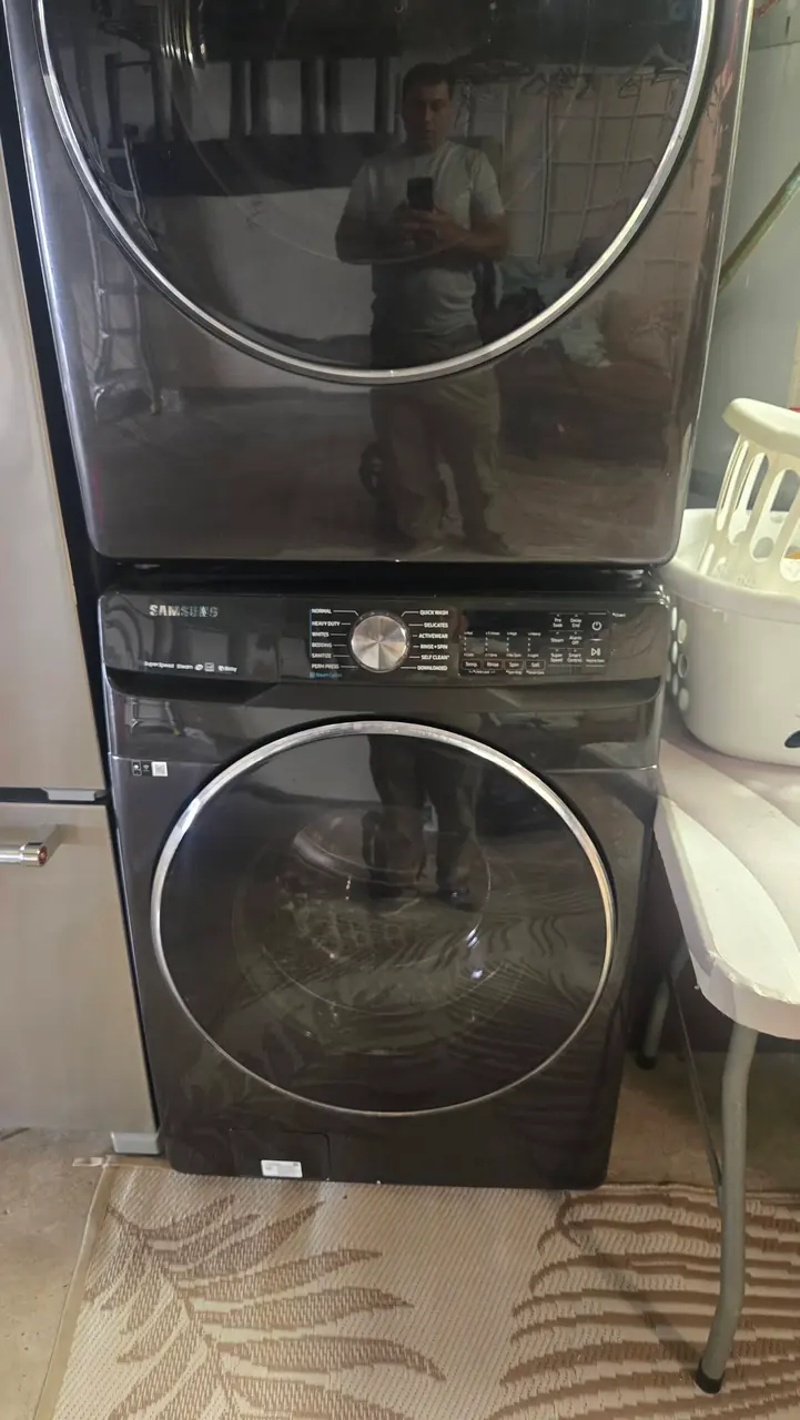 Black stainless Samsung stacked washer and dryer installed in a San Diego laundry room
