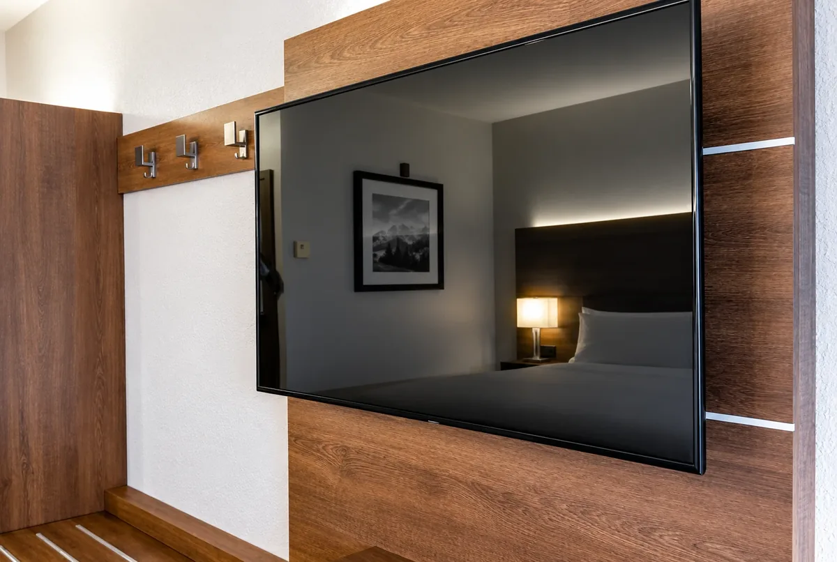 Flat-screen TV mounted level and flush on a wood-panel feature wall in a San Diego bedroom by AllPro AG